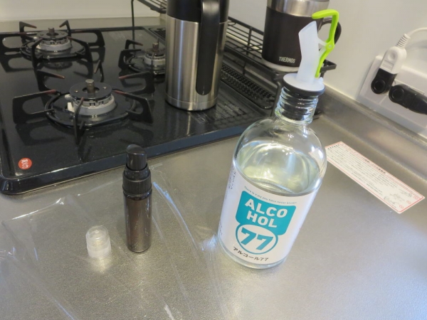 スイッチキャップ(ポアラー)をアルコール77の瓶に取り付け、スプレーボトルに注ぐ