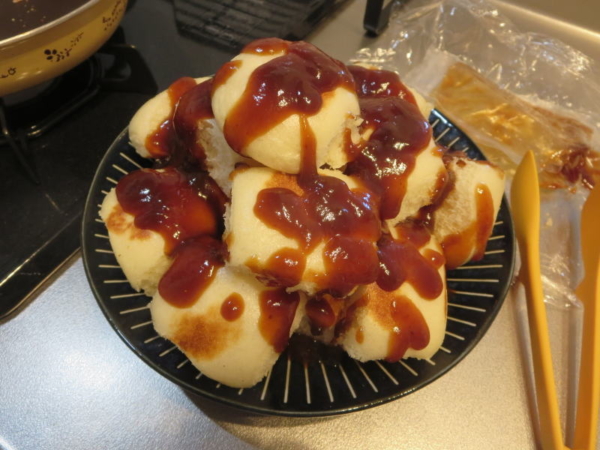 焼いた焼まんじゅうにタレを塗る